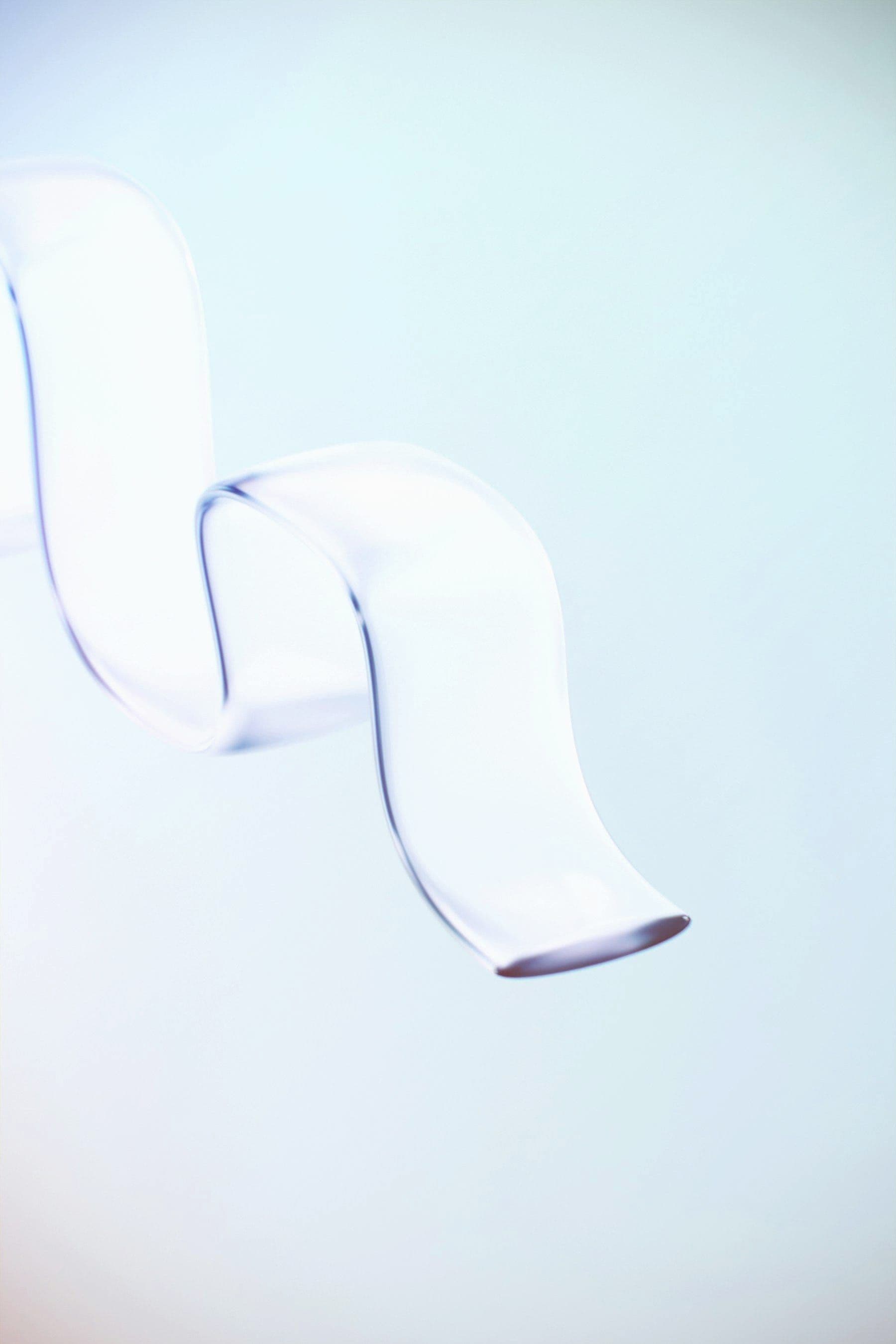 Translucent glass ribbon floating in pale light