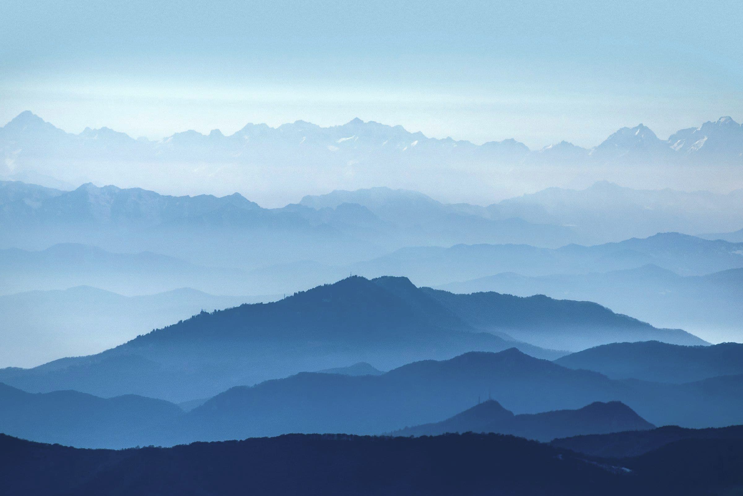 Layered misty mountain ridges in soft morning light